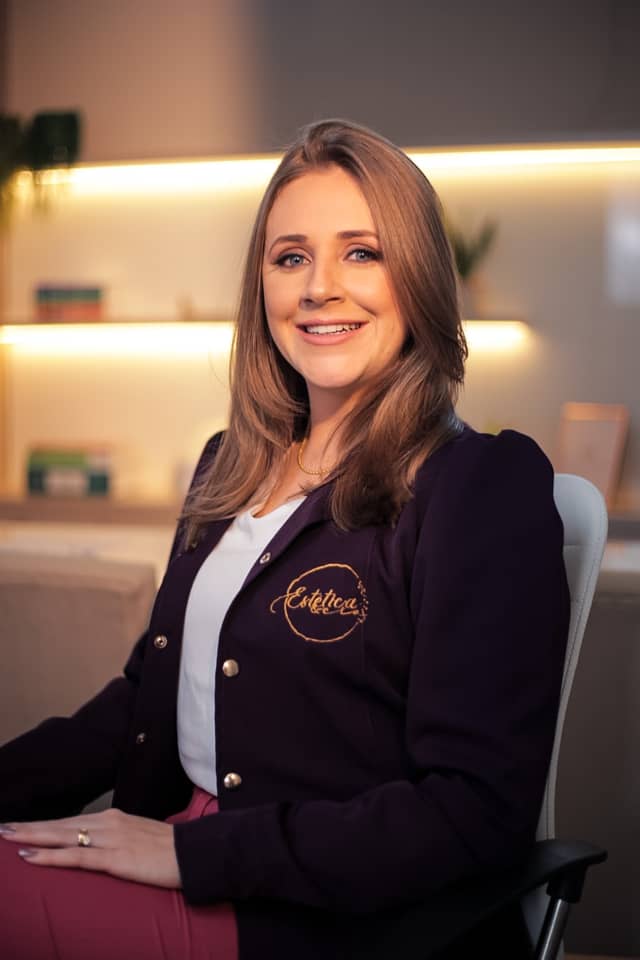 Eduarda Machado de cardigã vinho, sentada na mesma poltrona do consultório